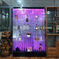 Shelving unit with bottles and decorative elements against a purple LED-lit background